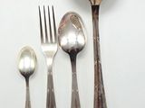 une cuillère, une fourchette et un repose-cuillère posés sur une surface blanche