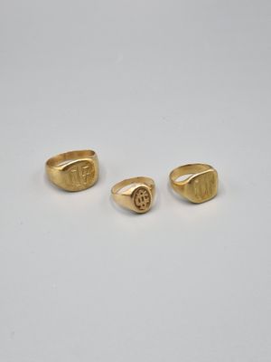 a pair of gold rings with the initials of a man and a woman