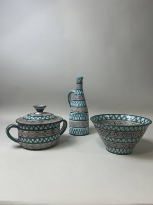 three pieces of blue and white pottery sitting on top of a table