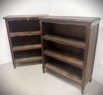 pair of antique wooden bookcases with open shelves in a room