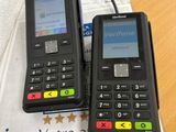 two cell phones sitting on top of a table next to each other