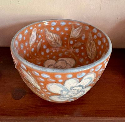 un bol posé sur une table à côté d'un vase
