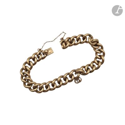 gros plan d'un bracelet en chaîne en or sur fond blanc