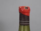 a bottle of wine that has a red cap on it