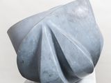 a gray sculpture on a white pedestal with a white background