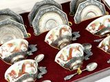 six tasses et soucoupes dans une boîte avec des cuillères