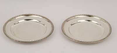a pair of silver plated dishes on a white background