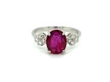 an oval ruby and diamond ring on a white background