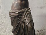 une statue représentant une femme debout devant un mur