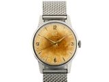 un gros plan d'une montre sur une surface blanche avec un fond blanc
