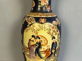 un vase avec un tableau posé sur une table