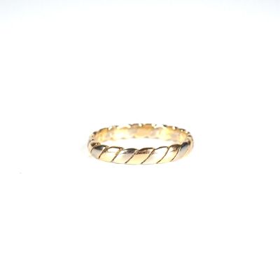 gros plan d'une bague en or sur une surface blanche