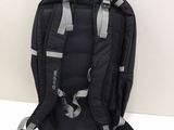 the back of a black backpack with silver straps on a white surface