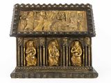 an ornate gold - plated casket with figures on it