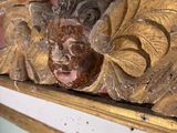 a wooden carving of a face on the wall