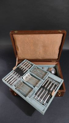 des couverts dans un coffret en bois sur fond noir