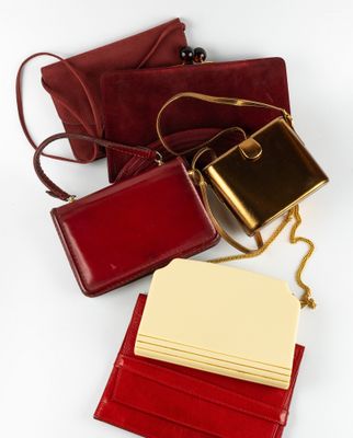 trois porte-monnaie en cuir rouge, dont l'un contient un bloc-notes et l'autre un bloc-notes