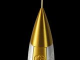 a gold and white rocket shaped object on a black background