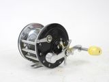 a close up of a fishing reel on a white surface