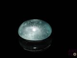 une image représentant une boule de jade verte posée sur une surface noire
