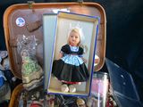 a doll in a suitcase with a picture of a little girl