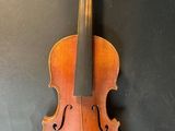 an old violin hanging on a wall with a black background