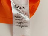 a close up of an orange shirt with a tag on it
