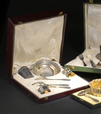 deux pièces d'argenterie dans un coffret posé sur une table