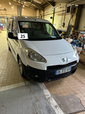 une camionnette blanche garée dans un garage, avec une plaque d'immatriculation