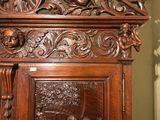 a wooden cabinet with carvings on the top of it