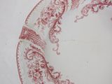 a red and white plate on a white table cloth