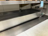 a conveyor belt in a bakery with donuts on it