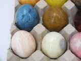 a carton of eggs with different colored eggs in it
