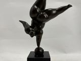 statue of a woman doing a handstand on a marble block
