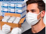 l'homme porte un masque à côté d'une boîte de masques