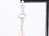 a close up of a pair of earrings with pearls and diamonds
