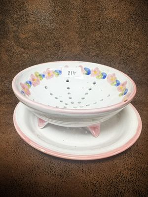 une assiette blanche bordée de rose et un bol blanc orné de fleurs