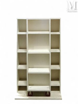 une bibliothèque blanche surmontée de quelques étagères