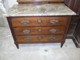 une commode au plateau en marbre, surmontée d'un miroir