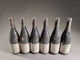 six bottles of wine are lined up in a row on a table