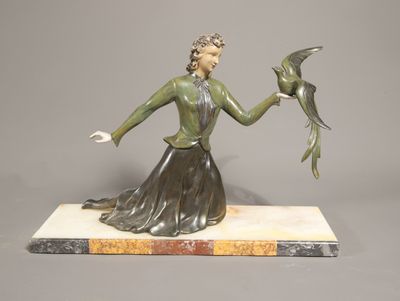 statue en bronze d'une femme tenant un oiseau sur un socle en marbre