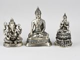 three silver figurines of buddhas on a white background