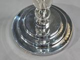 a silver plate with a glass candle holder on top of it
