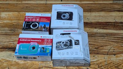 boxes of cameras sitting on a wooden surface next to each other