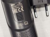a close up of a black electric shaver and a charger