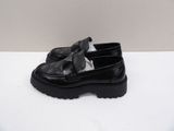 a close up of a pair of black shoes on a white surface
