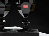 two wine glasses sitting on top of a black stand