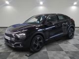 a black car is parked on a checkered floor in a garage