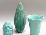 three vases and a vase on a white surface with a gray background