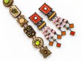 une photo en gros plan d'un collier et de boucles d'oreilles posés sur une surface blanche